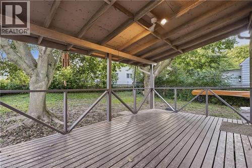 Covered wood deck with wooden railings, exposed wood beam ceiling, and overhead lighting - 160 Lorne Crescent, Kitchener, ON 
