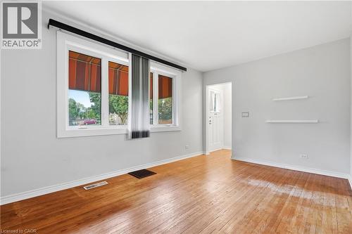 Hardwood flooring throughout, white trim, dual windows, and a white paneled entry door - 160 Lorne Crescent, Kitchener, ON 