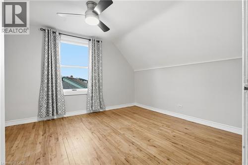Hardwood flooring, painted walls, window with trim, sloped ceiling, and a ceiling fan - 160 Lorne Crescent, Kitchener, ON 