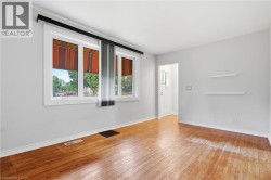 Hardwood flooring throughout, white trim, dual windows, and a white paneled entry door - 
