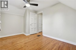 Hardwood flooring, painted walls, ceiling fan, white trim, and paneled interior doors - 