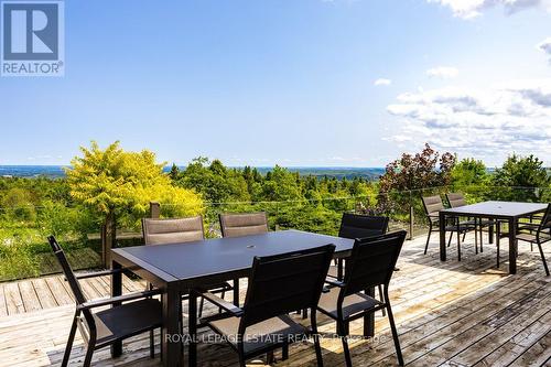 Deck runs length of house with soft seating. - 798377 Third Line E, Mulmur, ON 