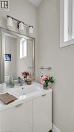 Vanity with a built-in sink, chrome faucet, framed mirror, and contemporary light fixture - 
