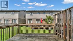 Wooden deck with railings overlooking a grassy yard - 