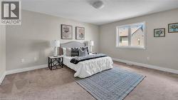 Neutral wall paint, light-toned carpeting, ample natural light from a multi-pane window, and a flush-mount ceiling light - 