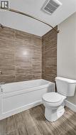Tub and shower combination with full-height tile surround, curved shower rod, and wood-finish tile flooring - 