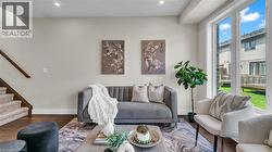 Recessed lighting, wood-finish flooring, staircase with carpeted treads and wood handrail, large windows, and light-toned walls - 