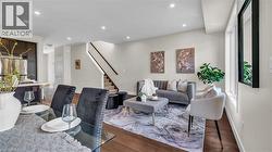 Vaulted ceiling, recessed lighting, wood-finish flooring, staircase with wood handrail, multiple windows with trim - 