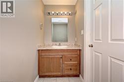 Vanity with wood-finish cabinetry, light-colored countertop, and integrated sink - 