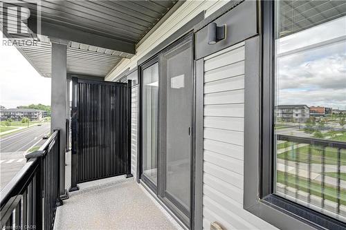 Private balcony with black metal railings, textured flooring, and a sliding glass door - 102 Wheat Lane, Kitchener, ON 