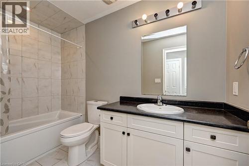 Bathroom with tiled flooring, white vanity, dark countertop, and integrated sink - 102 Wheat Lane, Kitchener, ON 