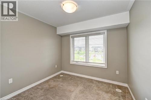 Neutral-toned walls, carpeted flooring, window with horizontal blinds, flush mount ceiling light fixture, white trim - 102 Wheat Lane, Kitchener, ON 