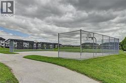 Basketball court with chain-link fencing, surrounded by green space - 