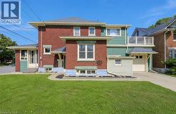 Cement driveway, metal roof, sunroom entrance, walkup basement entrance, garage with inside entry. - 