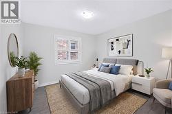 Bedroom featuring wood-finish flooring, a window with plantation shutters, and a ceiling-mounted light fixture - 