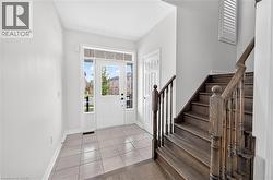 Entry foyer featuring a transom window, sidelights, and light-toned tile flooring - 