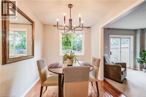 Hardwood-finish flooring, built-in chandelier, white window frames, painted walls, and sliding glass door - 360 Cornridge Place Unit# 2, Waterloo, ON 