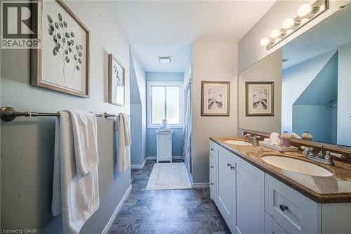 Double vanity with integrated sinks, granite countertop, white cabinetry, and brushed nickel hardware - 360 Cornridge Place Unit# 2, Waterloo, ON 
