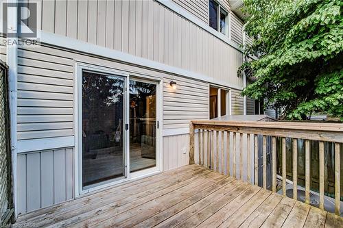 Wood deck with railing, featuring sliding glass door access, exterior wall sconce, and horizontal siding - 360 Cornridge Place Unit# 2, Waterloo, ON 