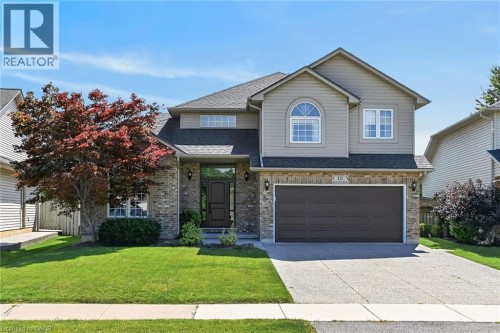 Brick and siding exterior with an arched window, double front entry door, and an attached two-car garage - 10 Balvenie Boulevard, Caledonia, ON 