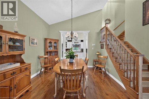 Vaulted ceiling, wood-finish flooring, staircase with wood banister, decorative archway, and overhead chandelier - 10 Balvenie Boulevard, Caledonia, ON 