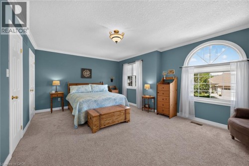 Spacious room featuring broadloom carpeting, a large arched window, a secondary window, and a ceiling-mounted light fixture - 10 Balvenie Boulevard, Caledonia, ON 