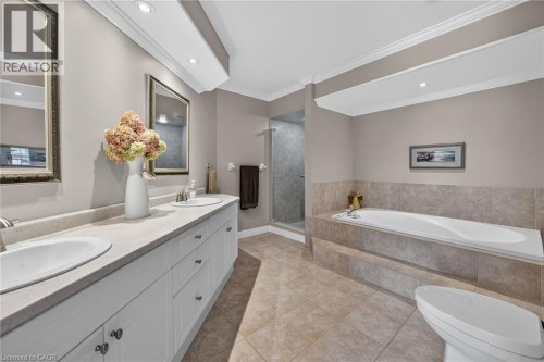 Dual vanity with undermount sinks, built-in soaking tub with tiled surround, walk-in shower with glass enclosure, recessed lighting, and crown molding - 10 Balvenie Boulevard, Caledonia, ON 