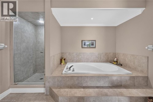Built-in soaking tub with tiled surround, separate glass-enclosed shower, tiled flooring, and crown molding - 10 Balvenie Boulevard, Caledonia, ON 