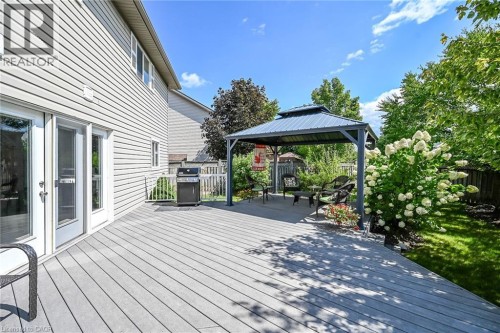 Expansive deck with a built-in gazebo, featuring gray decking and white French doors - 10 Balvenie Boulevard, Caledonia, ON 