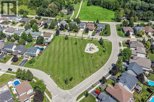 Expansive green space with an integrated playground, surrounded by residential properties and paved roadways - 10 Balvenie Boulevard, Caledonia, ON 