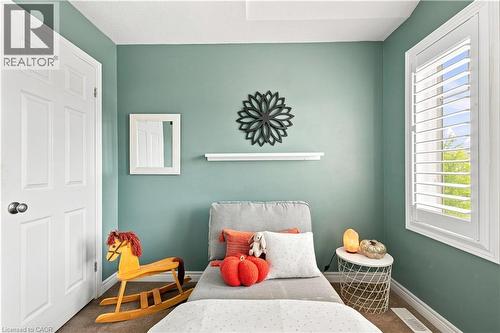 Window with white plantation shutters, white paneled door, and neutral tone wall-to-wall carpeting - 187 Eden Oak Trail, Kitchener, ON 