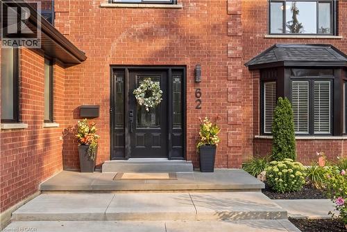 Brick facade with decorative banding, black-framed windows, and a black front entry door with sidelights - 62 Corfield Drive, Kitchener, ON 