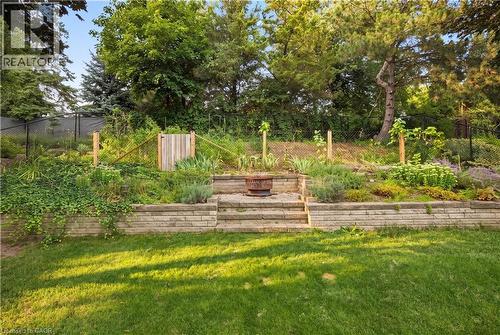 Expansive lawn area with a multi-tiered stone retaining wall and integrated steps - 62 Corfield Drive, Kitchener, ON 