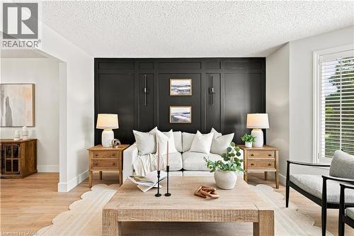Accent wall with wainscoting detail, wood-finish flooring, and white window blinds - 62 Corfield Drive, Kitchener, ON 