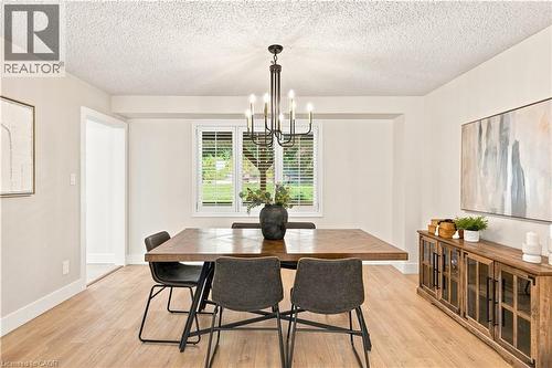 Hardwood-style flooring, white trim, recessed lighting, chandelier, and window with blinds - 62 Corfield Drive, Kitchener, ON 