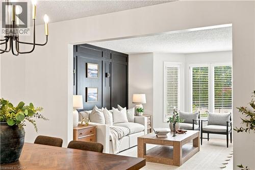 Open-concept living space featuring a wood-finish dining table and a black chandelier - 62 Corfield Drive, Kitchener, ON 