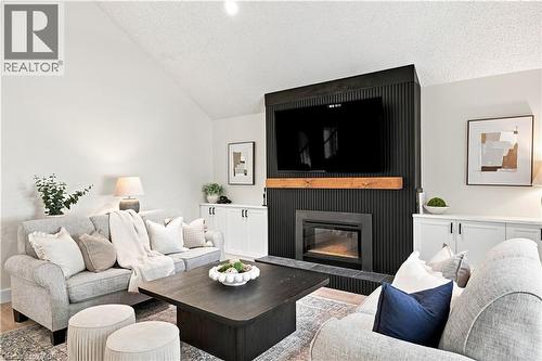 Vaulted ceiling, built-in fireplace, custom built-ins, wood mantel, and wood-finish flooring - 62 Corfield Drive, Kitchener, ON 