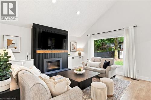 Vaulted ceiling, fireplace with wood mantel, built-in cabinetry, large window, wood-finish flooring - 62 Corfield Drive, Kitchener, ON 