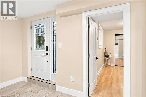 Entryway featuring a white paneled door with decorative glass, tile flooring, and light-toned walls - 62 Corfield Drive, Kitchener, ON 