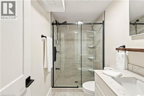 Glass-enclosed shower with subway tile surround, matte black fixtures, and a corner shelving unit - 62 Corfield Drive, Kitchener, ON 
