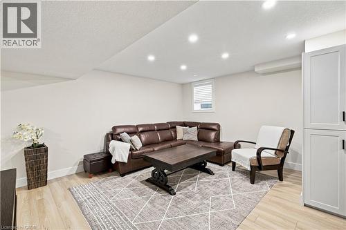 Recessed lighting illuminates the space, featuring light wood-finish flooring and white walls - 62 Corfield Drive, Kitchener, ON 
