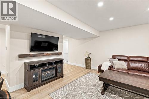Recessed lighting, light wood-finish flooring, and a built-in media console with an electric fireplace - 62 Corfield Drive, Kitchener, ON 