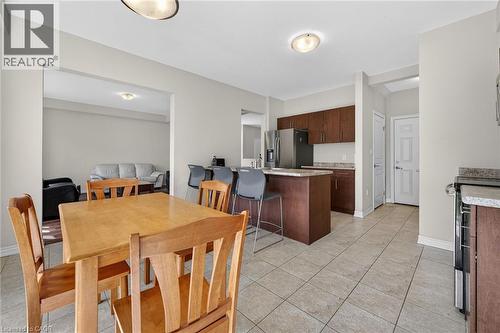 Kitchen with wood-finish cabinetry, stainless steel refrigerator, and granite-look countertops - 9 Winterberry Boulevard, Thorold, ON 