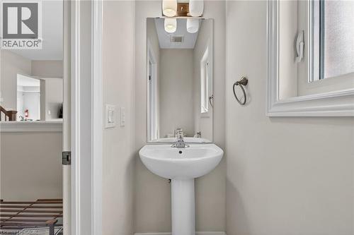 Pedestal sink with chrome fixtures and a rectangular mirror - 9 Winterberry Boulevard, Thorold, ON 