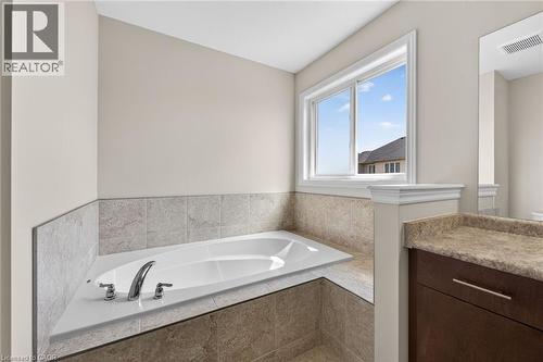 Built-in corner tub with chrome fixtures, surrounded by tile - 9 Winterberry Boulevard, Thorold, ON 