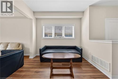 Wood-finish flooring with white baseboards, natural light from a window with blinds, and neutral painted walls - 9 Winterberry Boulevard, Thorold, ON 