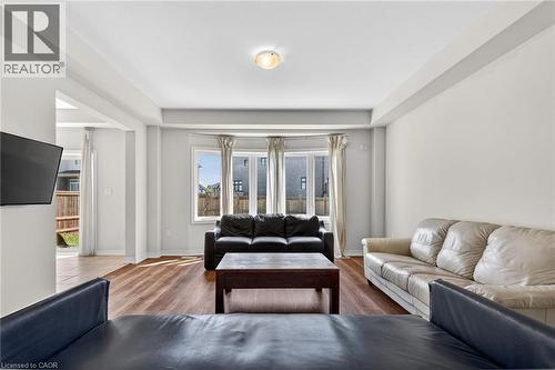 Wood-finish flooring throughout, featuring a bay window, recessed ceiling, and a flush mount ceiling light - 9 Winterberry Boulevard, Thorold, ON 