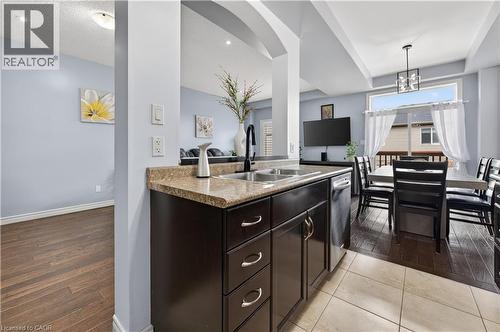 Kitchen area with dark wood-finish cabinetry, a double basin sink, and a dishwasher - 88 Highgate Drive, Hamilton, ON 