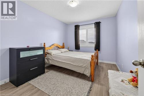 Wood-finish flooring with white baseboards and light purple wall color - 88 Highgate Drive, Hamilton, ON 