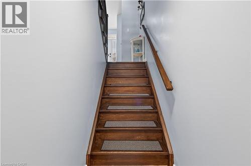 Hardwood staircase with a wood handrail and light-toned wall finishes - 88 Highgate Drive, Hamilton, ON 